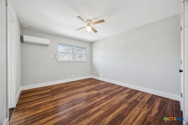 a view of a room with wooden floor and white walls