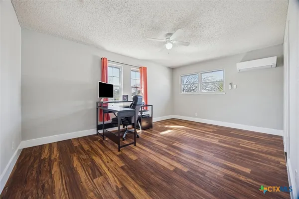 a view of a workspace with furniture and wooden floor