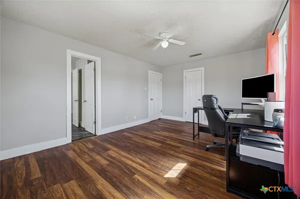 a view of a workspace with furniture and wooden floor