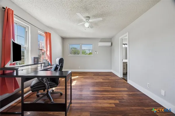 a view of a workspace with furniture window and wooden floor