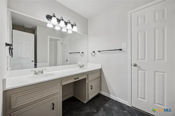 a spacious bathroom with a double vanity sink and a mirror