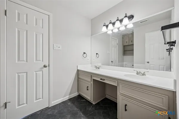 a bathroom with a double vanity sink and a mirror