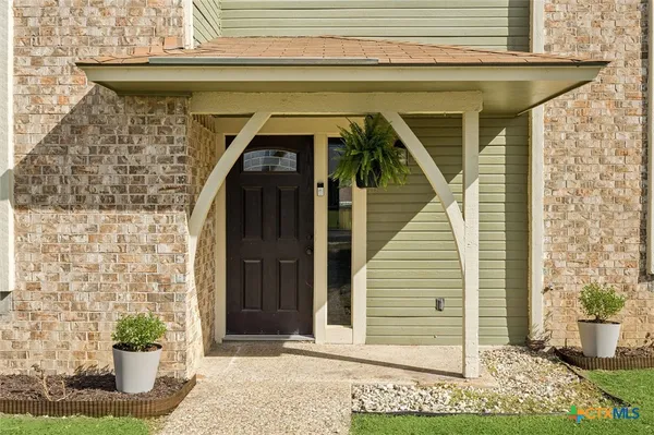 a front view of a house with plants