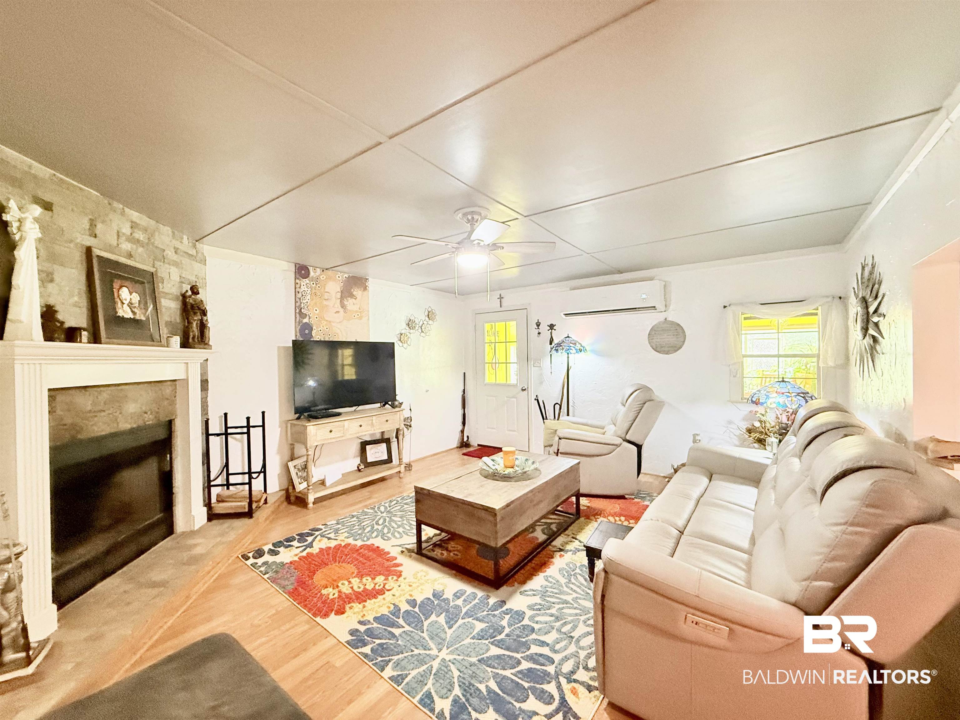 21305 River Road Robertsdale, AL 36567 - Photo 36 of 50 Living area featuring a wall unit AC, ceiling fan, plenty of natural light, and wood finished floors