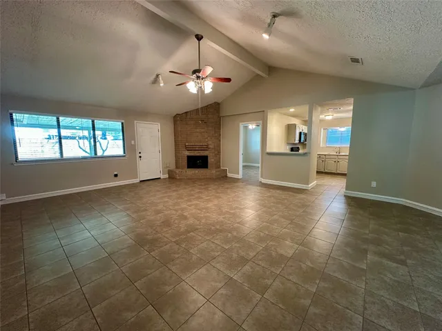 an empty room with a fireplace and chandelier