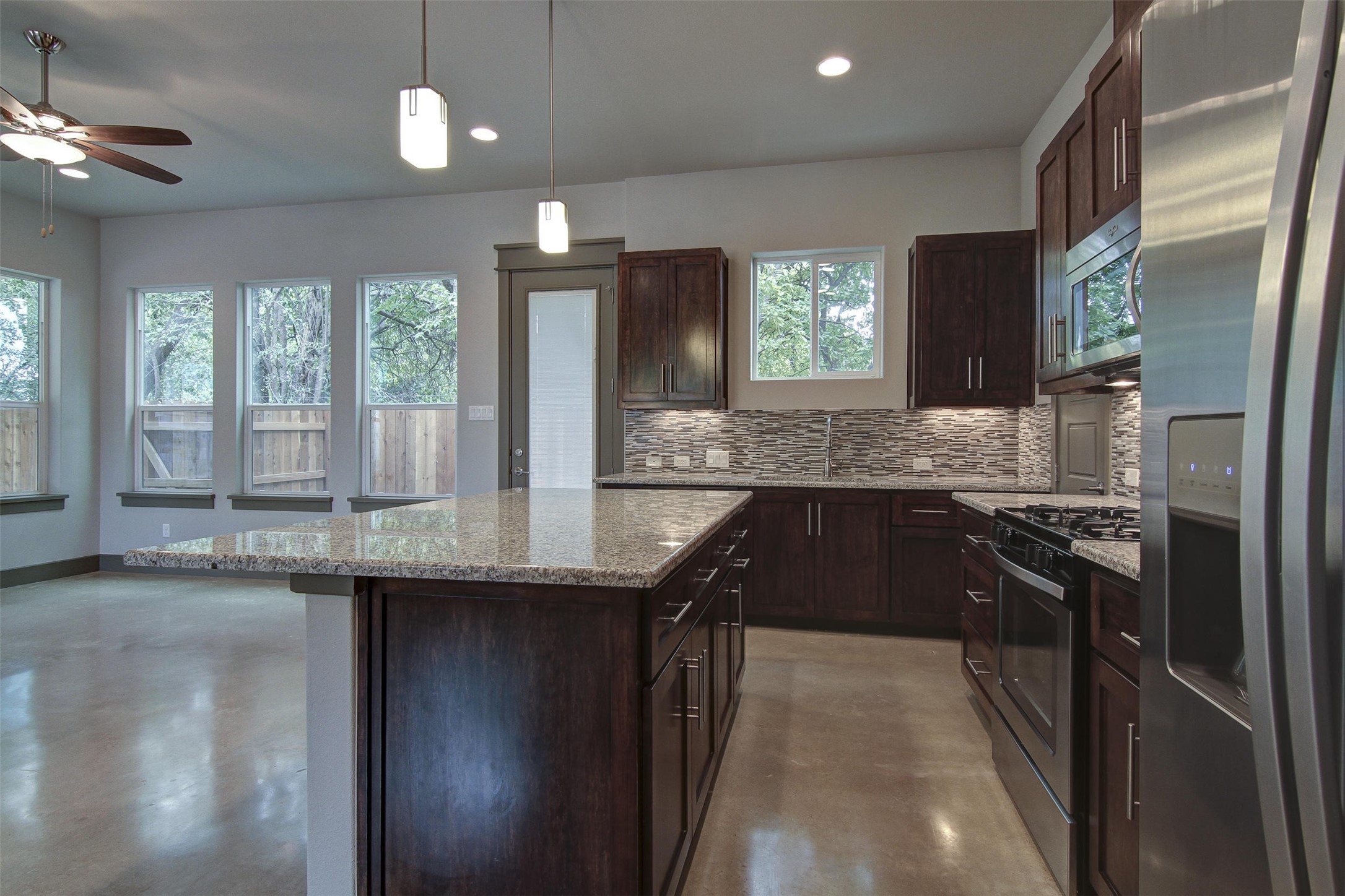 923 East 37th Street Austin, TX 78705 - Photo 14 of 36 a kitchen with stainless steel appliances granite countertop a sink a stove and a refrigerator