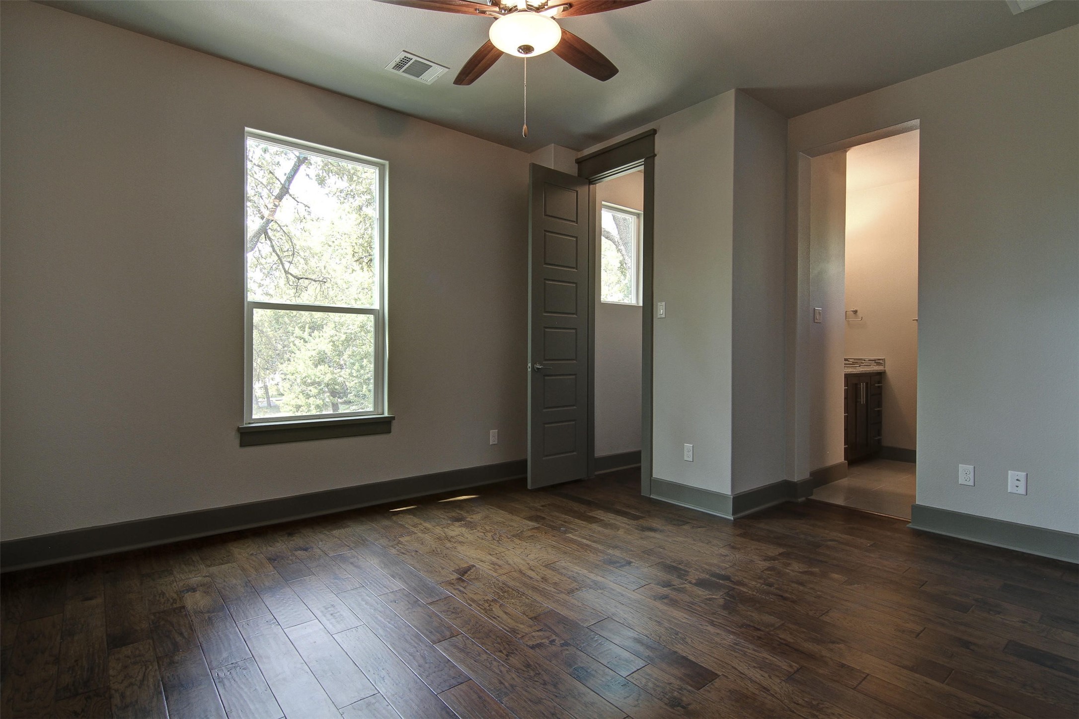 923 East 37th Street Austin, TX 78705 - Photo 26 of 36 an empty room with wooden floor chandelier fan and windows