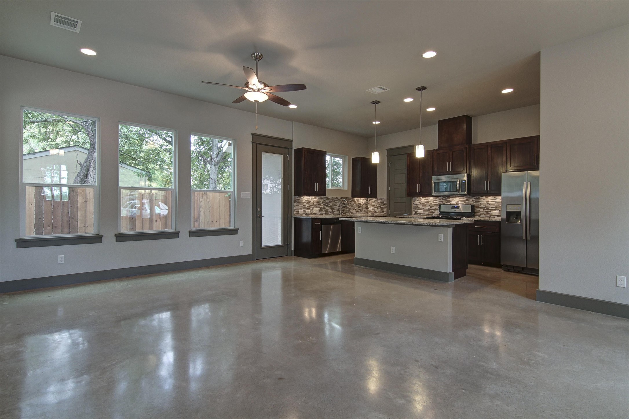 923 East 37th Street Austin, TX 78705 - Photo 6 of 36 a view of a kitchen with kitchen island a sink wooden floor and a large window