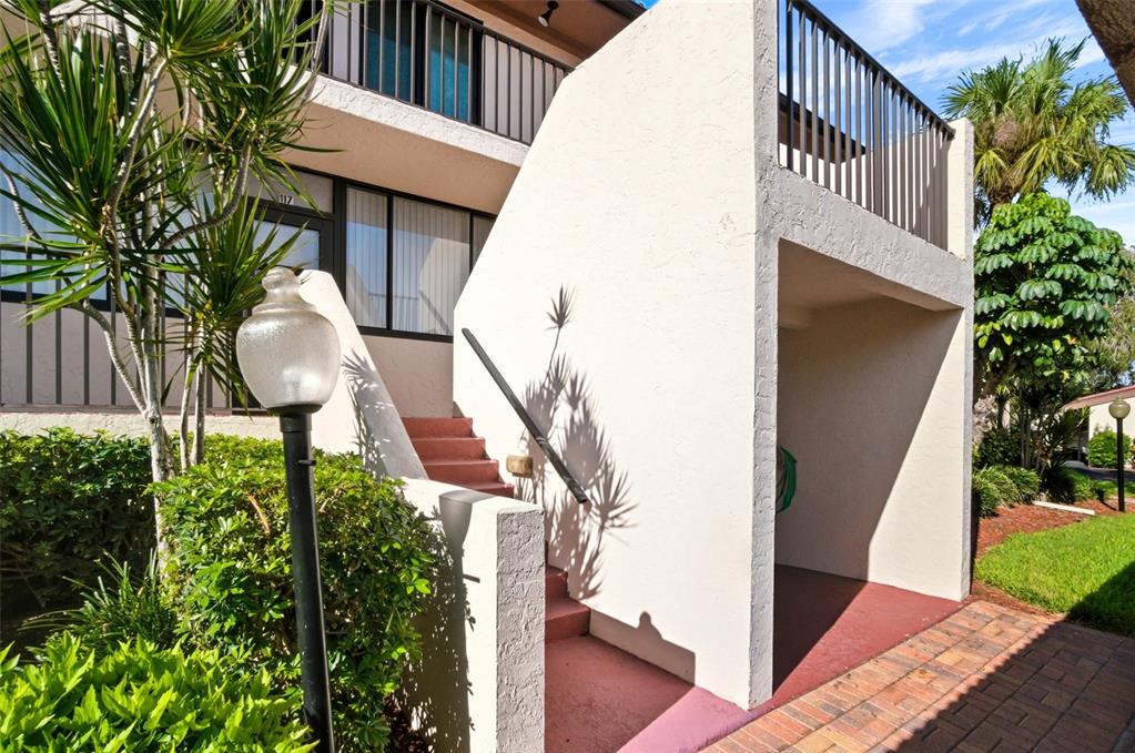 3420 Wild Oak Bay Boulevard, Unit 118 Bradenton, FL 34210 - Photo 1 of 40 a backyard of a house with table and chairs potted plants and large tree