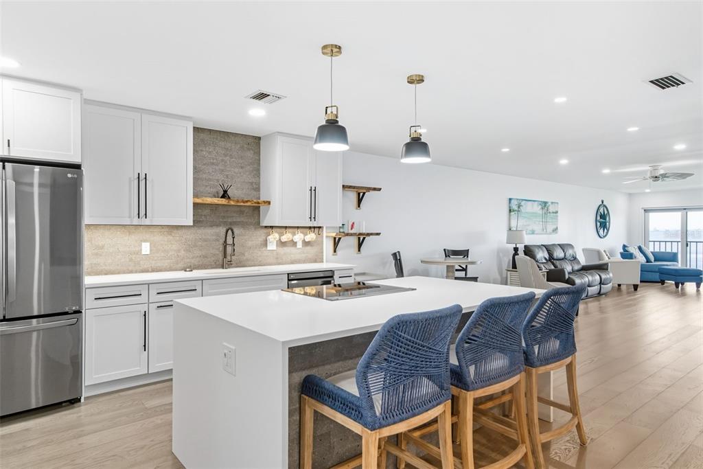 3420 Wild Oak Bay Boulevard, Unit 118 Bradenton, FL 34210 - Photo 11 of 40 a kitchen with a dining table chairs refrigerator and microwave