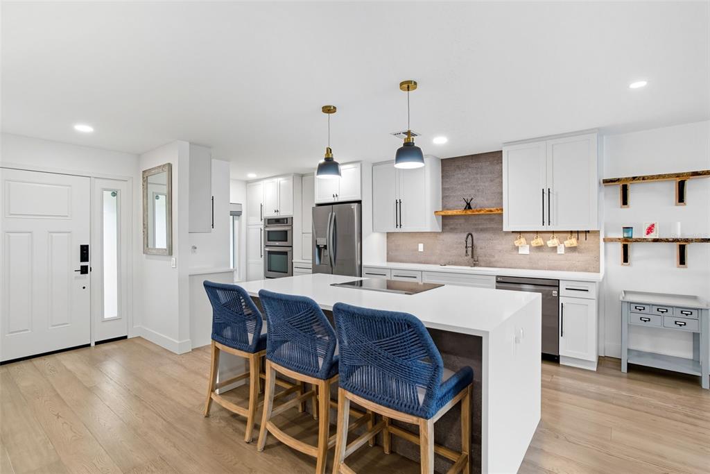 3420 Wild Oak Bay Boulevard, Unit 118 Bradenton, FL 34210 - Photo 9 of 40 a kitchen with stainless steel appliances kitchen island granite countertop a table chairs sink and cabinets