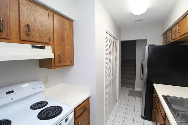 a kitchen with a refrigerator and a stove top oven