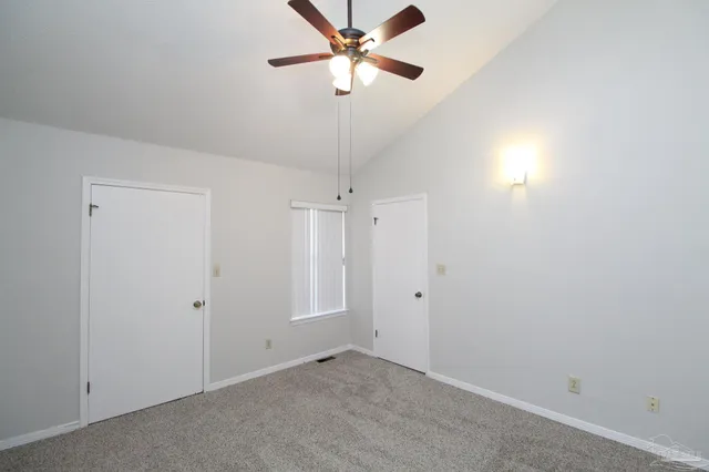 a view of a room with a ceiling fan and a fan