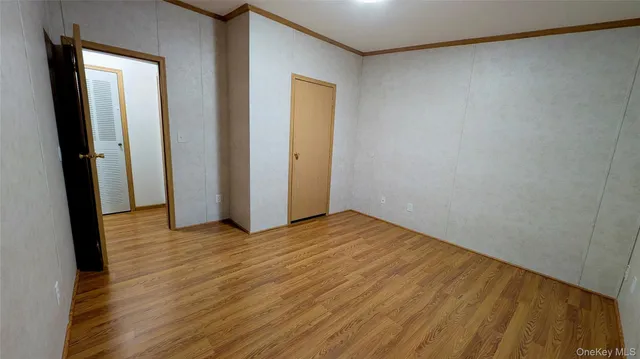 a view of a room with wooden floor and a ceiling fan