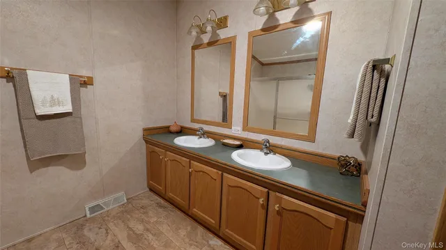 a bathroom with a granite countertop sink a mirror and a shower