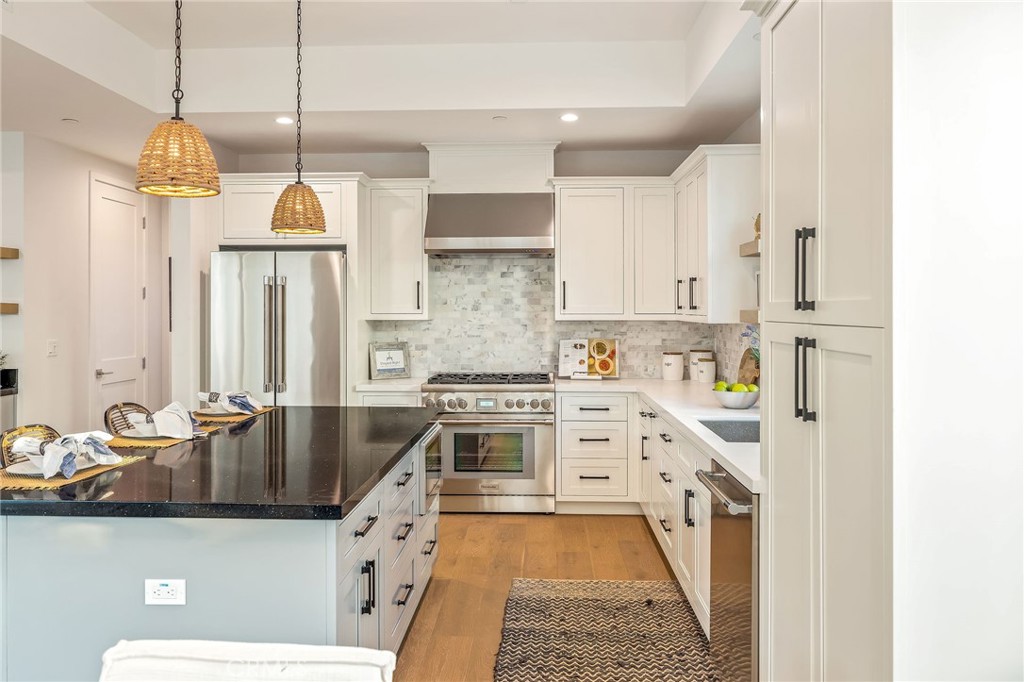 2016 Clark Lane, Unit B Redondo Beach, CA 90278 - Photo 9 of 31 a kitchen with stainless steel appliances a stove a sink a chimney wooden floor and cabinets