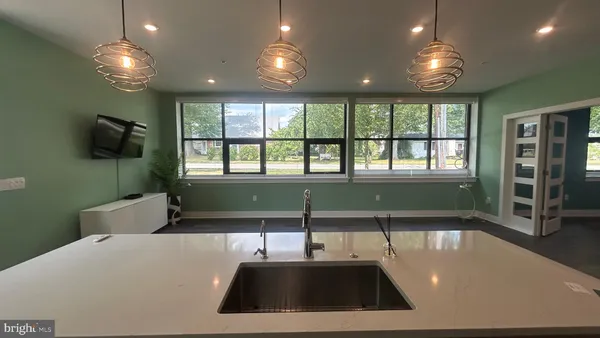 a view of an empty room with wooden floor and entryway