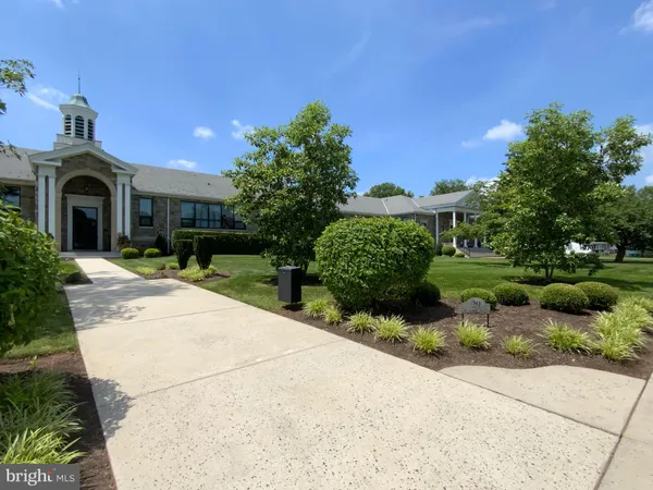 a front view of a house with a yard and potted plants