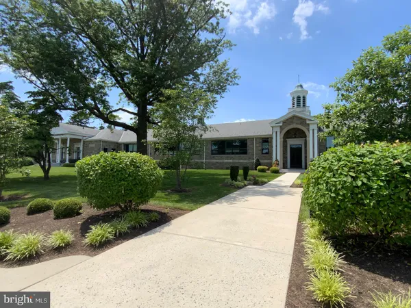 a front view of a house with a yard and shrubs