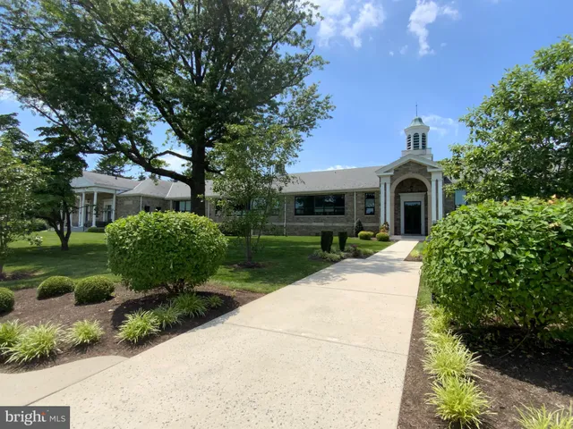 a front view of a house with a yard and shrubs