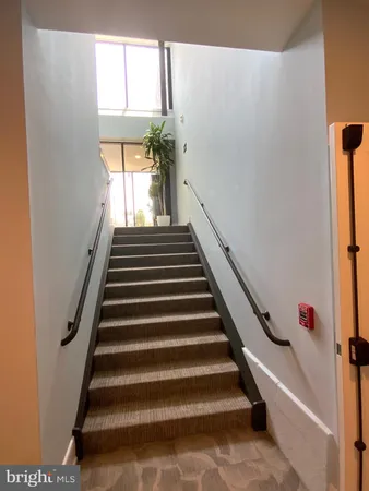 a view of a hallway with wooden floor and glass door