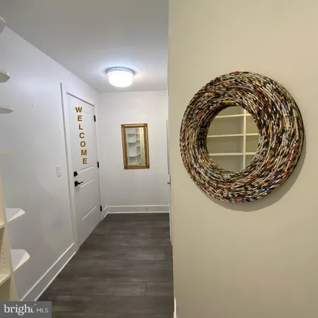 a view of a hallway with wooden floor and glass door