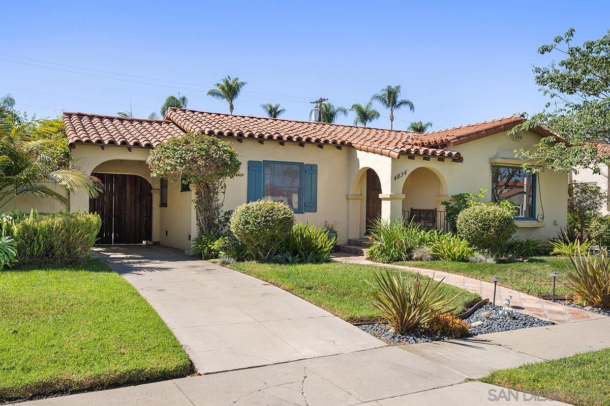4834 Canterbury Drive San Diego, CA 92116 - Photo 1 of 58 a view of a white house with a yard potted plants and a table