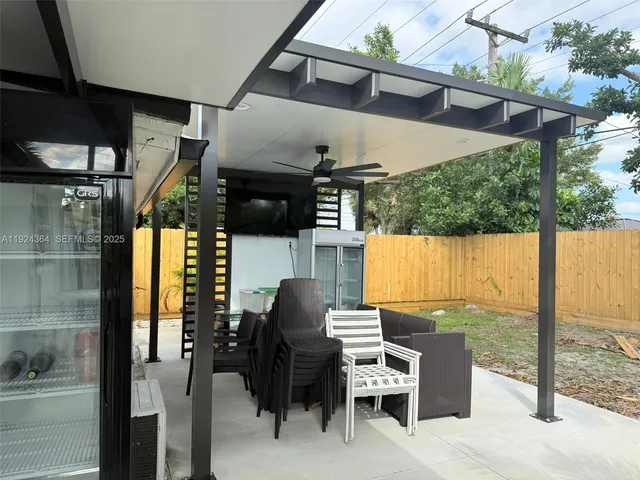 a view of a patio with a table chairs and backyard