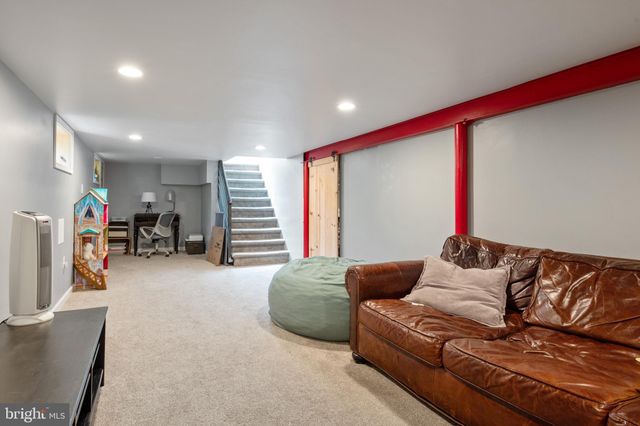 a living room with furniture and a gym cycle