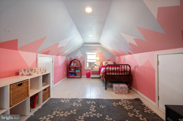 a view of a house with wooden fence next to a yard