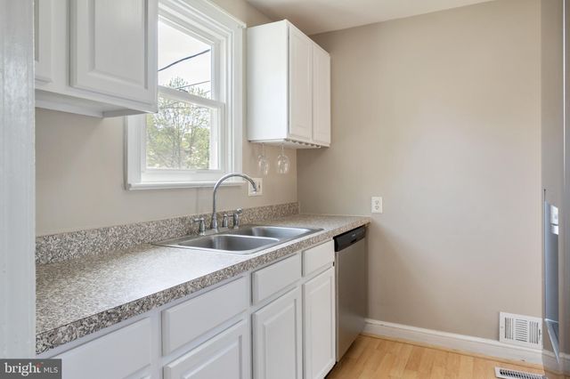 a bathroom with a granite countertop sink and a window