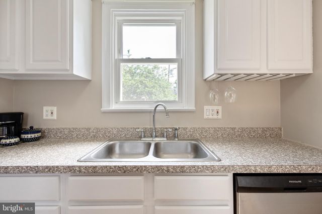 a kitchen with granite countertop white cabinets and a sink