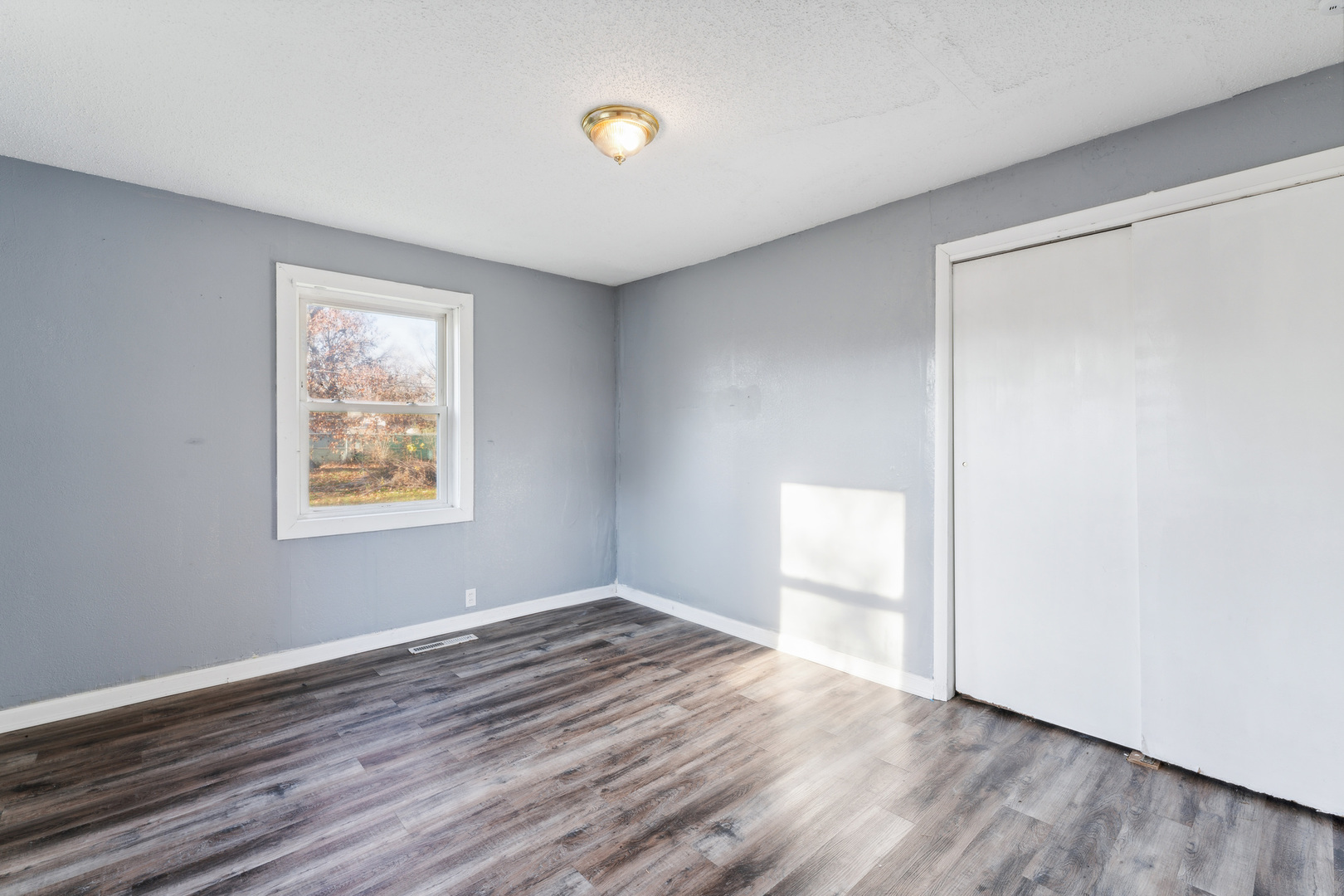 2042 Sandy Ridge Road Cahokia, IL 62206 - Photo 13 of 21 an empty room with wooden floor and windows
