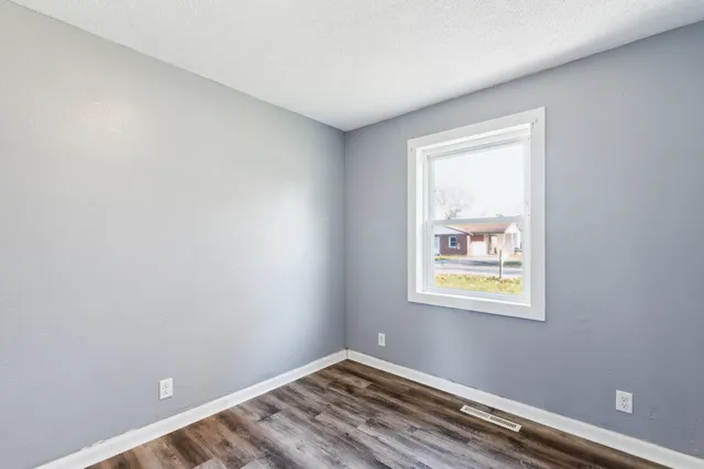 a view of room with window and wooden floor