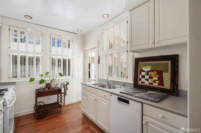 a living room with stainless steel appliances granite countertop a fireplace cabinets and a window