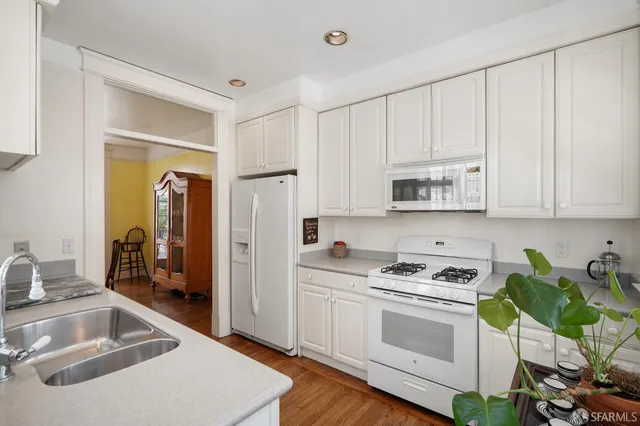 a kitchen with granite countertop a sink cabinets and stainless steel appliances