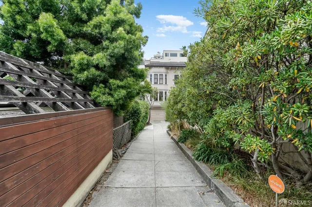 a view of a house with a yard and potted plants