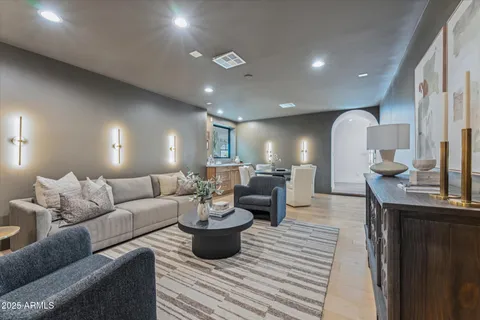 a view of a white house with a fountain and potted plants