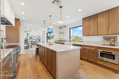a kitchen with stainless steel appliances kitchen island granite countertop a sink stove and cabinets