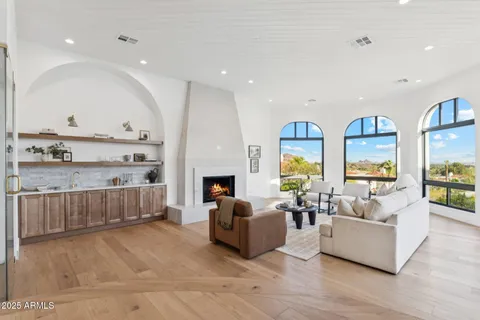 a living room with furniture a fireplace and a chandelier