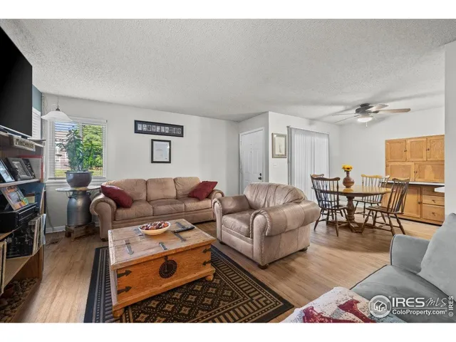a living room with furniture a flat screen tv and a table