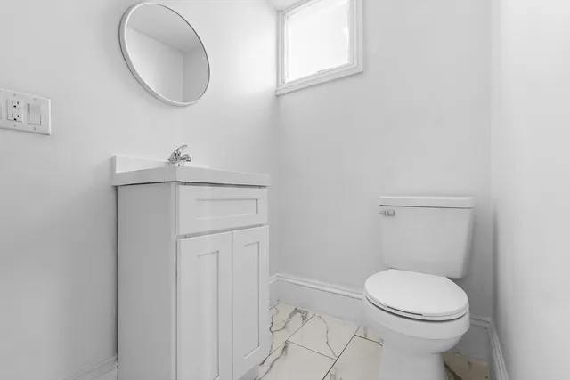 a bathroom with a toilet a sink and mirror