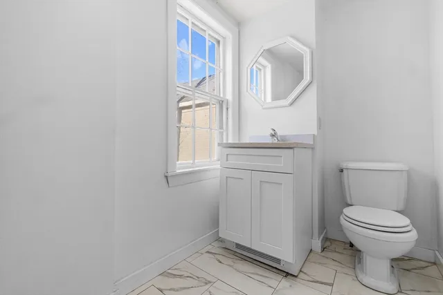 a bathroom with a toilet a sink and mirror