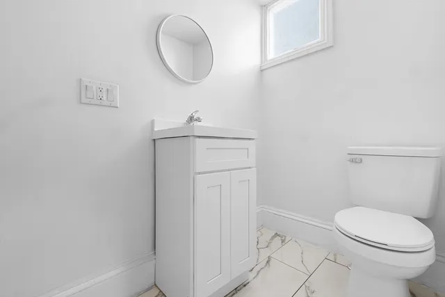 a bathroom with a toilet a sink and mirror