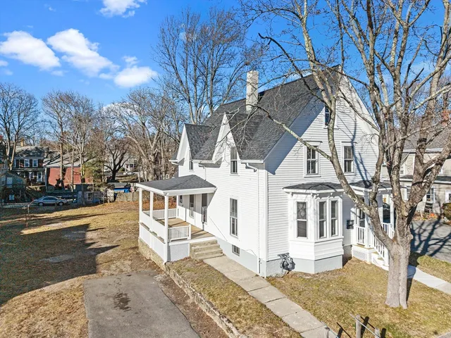 a view of a white house with a yard covered in snow