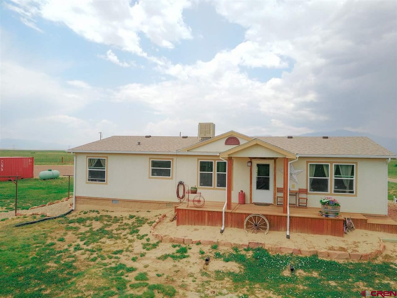 3101 County Road 110 Rye, CO 81069 - Photo 23 of 29 a view of a white house with a big yard and potted plants