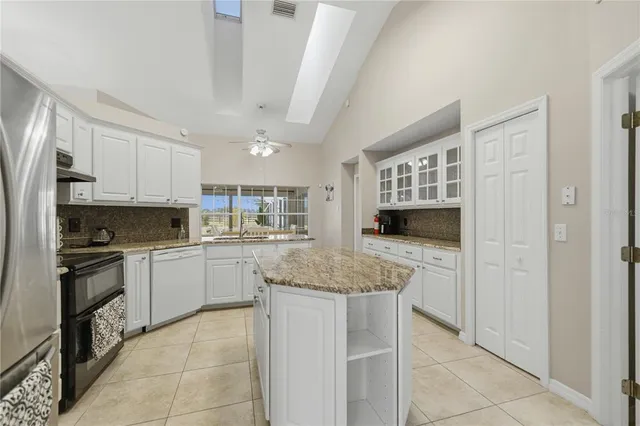 a kitchen with stainless steel appliances granite countertop a stove top oven a sink dishwasher and a refrigerator