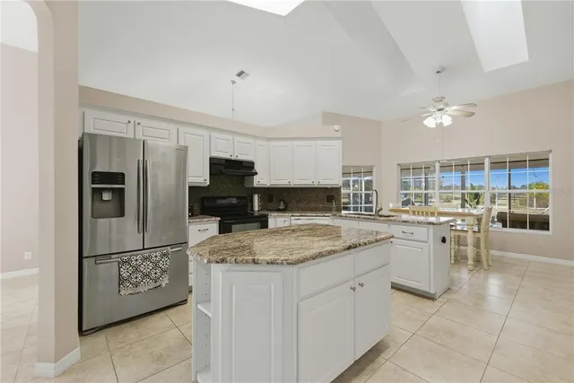 a kitchen with stainless steel appliances granite countertop a refrigerator oven a sink and dishwasher