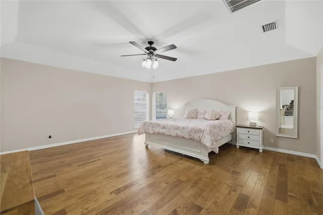 a spacious bedroom with a bed and a ceiling fan