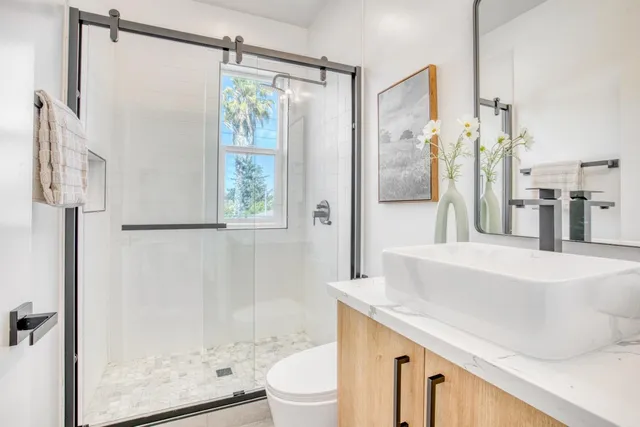 a bathroom with a sink a toilet and shower